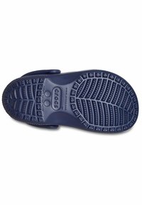 Námořnicky modrá gumová podrážka obuvi s texturovaným protiskluzovým vzorem, která obsahuje vyvýšené tečky a drážky pro lepší přilnavost. Obsahuje značku "crocs."