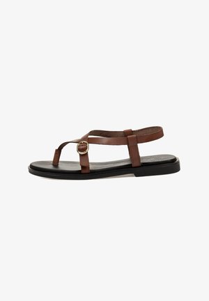 Sandalias de cuero marrón con tiras planas y un diseño simple que presenta una hebilla dorada y una suela negra, sobre un fondo blanco.