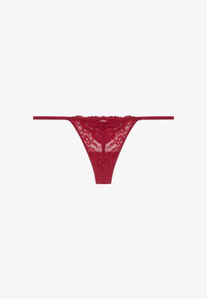 Rote Spitzenstring-Dessous mit floralen Mustern, minimaler Bedeckung und dünnen Trägern. Die Kanten sind gewellt für einen zarten Abschluss. Weicher, strukturierter Stoff.