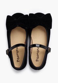 Bailarinas de terciopelo negro con un gran lazo en la parte delantera, correa de tobillo de charol y plantilla de suave color beige. Punta y tacón texturizados.