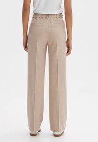 Beige broek met wijde pijpen en een relaxte pasvorm, met plooien aan de voorkant, een elastische tailleband en twee achterzakken, gemaakt van lichtgewicht stof.