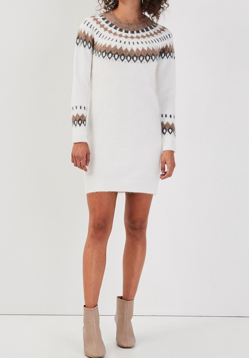 Robe tricotée blanche avec une silhouette ajustée, présentant un col rond, un motif tricoté en brun et noir, des manches longues et une texture douce.