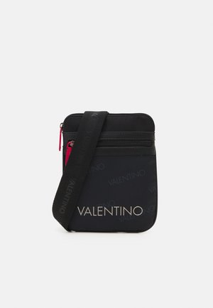 Schwarze Umhängetasche mit verstellbarem Riemen, vorderer Reißverschlusstasche und "VALENTINO"-Logo in großem und kleinerem, wiederholtem Text.
