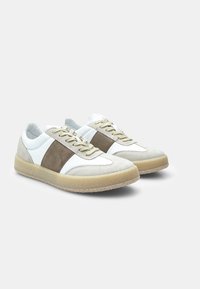 Sneaker in suede bianco e taupe con suole in gomma beige, dotate di una striscia centrale in suede e lacci piatti. Design atletico classico.