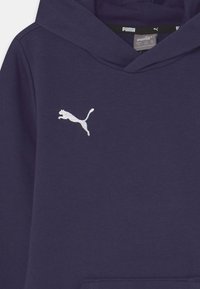 Sudadera marina hecha de tela suave que cuenta con un bolsillo tipo canguro, puños acanalados y un logotipo de Puma bordado en blanco en el lado izquierdo del pecho.