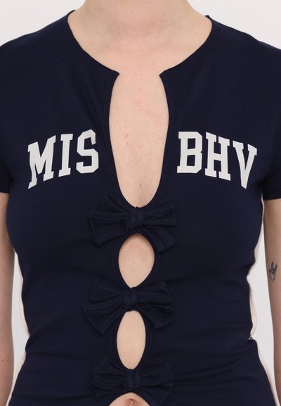 Navy cotton top featuring a deep neckline, cut-out holes secured by bow accents, and white text reading "MIS BHV" across the chest.