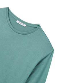 Maglietta verde chiaro a maniche lunghe realizzata in tessuto morbido con scollo rotondo. Presenta un'etichetta che indica la taglia small e una texture liscia.