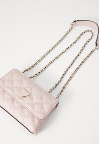 Gequiltete rosa Tasche mit einem dreieckigen Logo, goldener Kettenriemen und glatter Textur. Verfügt über einen Klappenverschluss und kontrastierenden schwarzen Besatz.