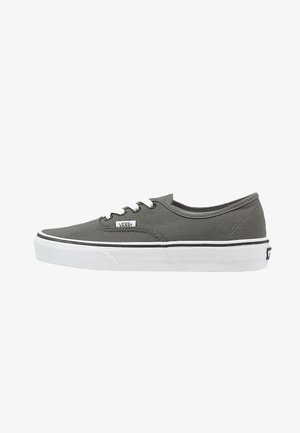 Gray canvas sneaker with white laces, flat white rubber sole, black side stripe, and Vans logo on the side. Low-profile design.