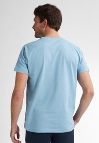 Lichtblauw katoenen t-shirt met korte mouwen, een ronde hals en een relaxte pasvorm. De achterkant heeft een subtiele stiksel detail en een label aan de onderkant.