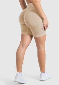 Shorts atletici beige a vita alta realizzati in tessuto testurizzato, caratterizzati da una finitura liscia e un design modellato per un miglior adattamento e supporto.