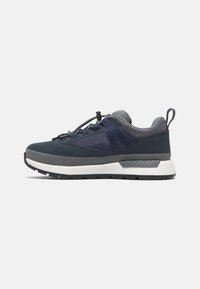 Sport shoes in dark blue and gray with a mix of materials. Features a rounded toe, adjustable laces, and textured accents on the sole.