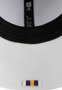Weißer Hut mit schwarzem Schirm. Hat eine gestreifte Akzentuierung in Lila, Gelb und Weiß auf der Vorderseite. Enthält ein New Era Label im Inneren.