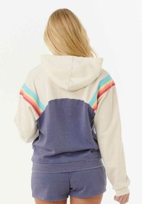 Hoody met crème- en marineblauwe kleurvlakken. Heeft regenboogstrepen over de schouders en een gestructureerde stof.
