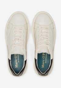 Tenisky s krémově bílým koženým svrškem, kulatou špičkou, béžovými tkaničkami a černými akcenty na bocích. Zelená stélka s brandingovým detailem.