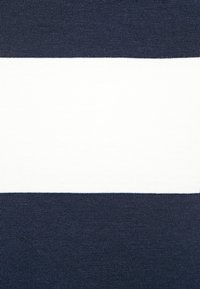 Marinblå och vit randig tyg med en slät yta, med ett brett vitt band i mitten och kontrasterande mörk marinblå sektioner högst upp och längst ner.