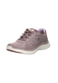 Zapatilla deportiva de color morado claro con parte superior de tela texturizada, diseño con cordones y suela blanca acolchada. Presenta un logo reflectante en el costado.