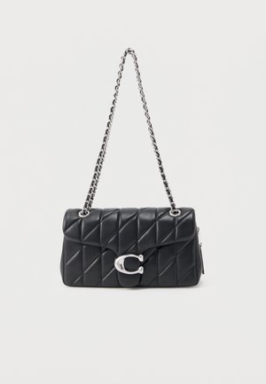 Crna prešivena kožna torba preko ramena sa srebrnim lancem i velikim srebrnim kopčom u obliku slova "C" na prednjem poklopcu.