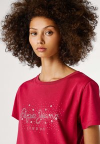 Rode katoenen T-shirt met een ronde hals, korte mouwen en decoratieve zilveren studs met de tekst "Pepe Jeans LONDON."