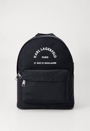 Black nylon backpack with curved top, front zip pocket, and white printed text. Features silver zipper pulls and smooth texture.