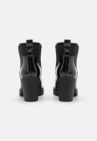 Mustad musta patendi nahast ankle-boots, millel on tekstuuriga elastsed külgpaneelid, plokkninad ja tugevdustatud tagumised tõmbetabandid lihtsaks jalga panemiseks.