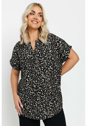 Sort kortærmet bluse med leopardmønster i beige og hvid, med en buet bund og design med klapkrave.