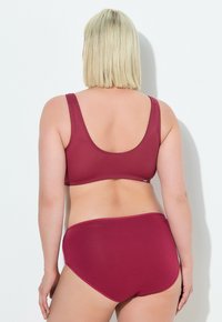 Burgunderfarbenes Damen-Lingerie-Set mit einem drahtlosen BH mit breiten Trägern und einem passenden hochgeschnittenen Slip. Glattes, elastisches Material mit nahtlosem Design.