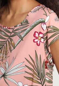 Světle růžový krátký rukáv top s tropickými listy a květinovými vzory; kulatý výstřih; měkká tkanina s mírným leskem; volný střih.