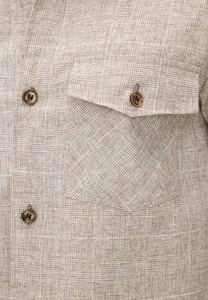 Camicia in tessuto a quadri beige con due bottoni in legno sul davanti e una tasca con patta e bottone sul petto.