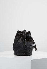 Czarna torba typu bucket wykonana z teksturowanego materiału imitującego skórę węża. Posiada zaciągany sznurek oraz miękki, zaokrąglony kształt.