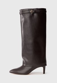 Bota de cuero negro hasta la rodilla con puntera afilada y tacón delgado. Presenta un borde plegado en la parte superior con un adorno de hebilla en tono dorado. Textura suave.