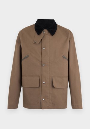 Geacă maro cu guler negru, închidere cu capse, două buzunare cu fermoar pe piept și două buzunare inferioare cu clapetă pe un fundal simplu.