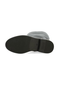 Suela de bota negra con una textura suave, forma redondeada, diseño de banda de rodadura prominente y logo de marca en relieve.