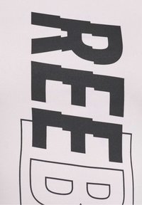 White fabric t-shirt featuring bold black printed text with a stylized design and geometric elements. Smooth texture and fitted shape.