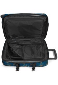 Maleta rodante con exterior azul que presenta un patrón geométrico, interior negro, un bolsillo con cremallera y un asa retráctil resistente.
