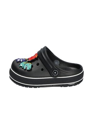 Czarne klapki typu slip-on z białymi paskami na podeszwie, ozdobione kolorowymi zawieszkami w kształcie dinozaurów na górnym pasku i w okolicy stopy.