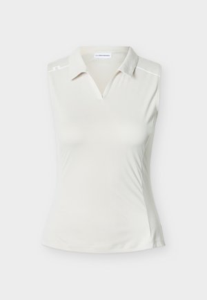 Αμάνικο πόλο πουκάμισο σε εκρού, με v-λαιμόκοψη, μαλακό ύφασμα και διακριτικές αντανακλαστικές λεπτομέρειες στους ώμους. Λείο ύφασμα.