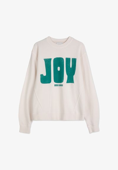 Krämfärgad sweatshirt med överdimensionerad textdesign i teal med ordet "JOY" och ribbade ärmslut. Mjuk, texturerad tyg med en avslappnad passform och rund halsringning.