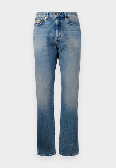 Kék farmernadrág egyenes lábakkal, enyhe kopással, aranygombos és szegecses részletekkel, valamint klasszikus öt zsebes kialakítással.