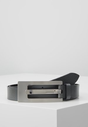Black leather belt with a textured finish and a large rectangular silver metal buckle, displayed coiled on a white surface.