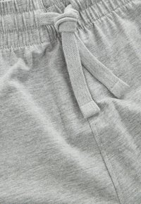 Grå bomullsshorts med elastisk midja och knytbar dragsko. Har en mjuk textur och subtilt melerat mönster.