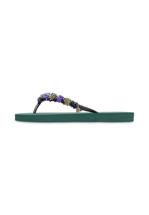 Sandale tongs verte avec des brides noires décorées de petites perles en forme de fleurs violettes et vertes et un petit pendentif métallique rond.