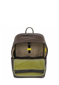 Brauner Leder-Rucksack mit einem sandfarbenen Innenraum, ausgestattet mit einer grünen Netztasche und einem gelben Etikett. Ein Reißverschluss und Riemen sind innen sichtbar.