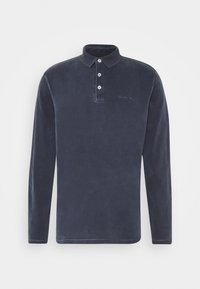 Marinblå långärmad polo med mjuk struktur, treknappsstängning och subtil broderad logotyp ovanför vänster sida.