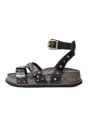 Sandale à plateforme noire avec semelle en liège, clous dorés sur les brides en cuir et bride de cheville avec boucle dorée.