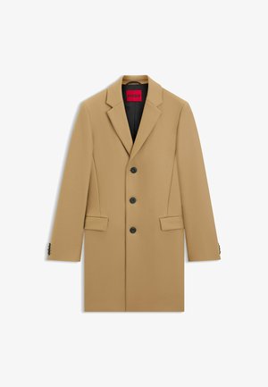 Beige maßgeschneiderter Mantel mit Reverskragen, drei schwarzen Knöpfen, seitlichen Taschen und schwarer Innenauskleidung. Glatte Oberfläche mit strukturiertem Design.