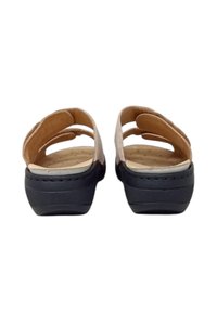 Sandali in pelle color cuoio con retro aperto e due cinturini larghi. Suola in gomma nera con fondo textured per una migliore aderenza. Soletta imbottita con perforazioni.