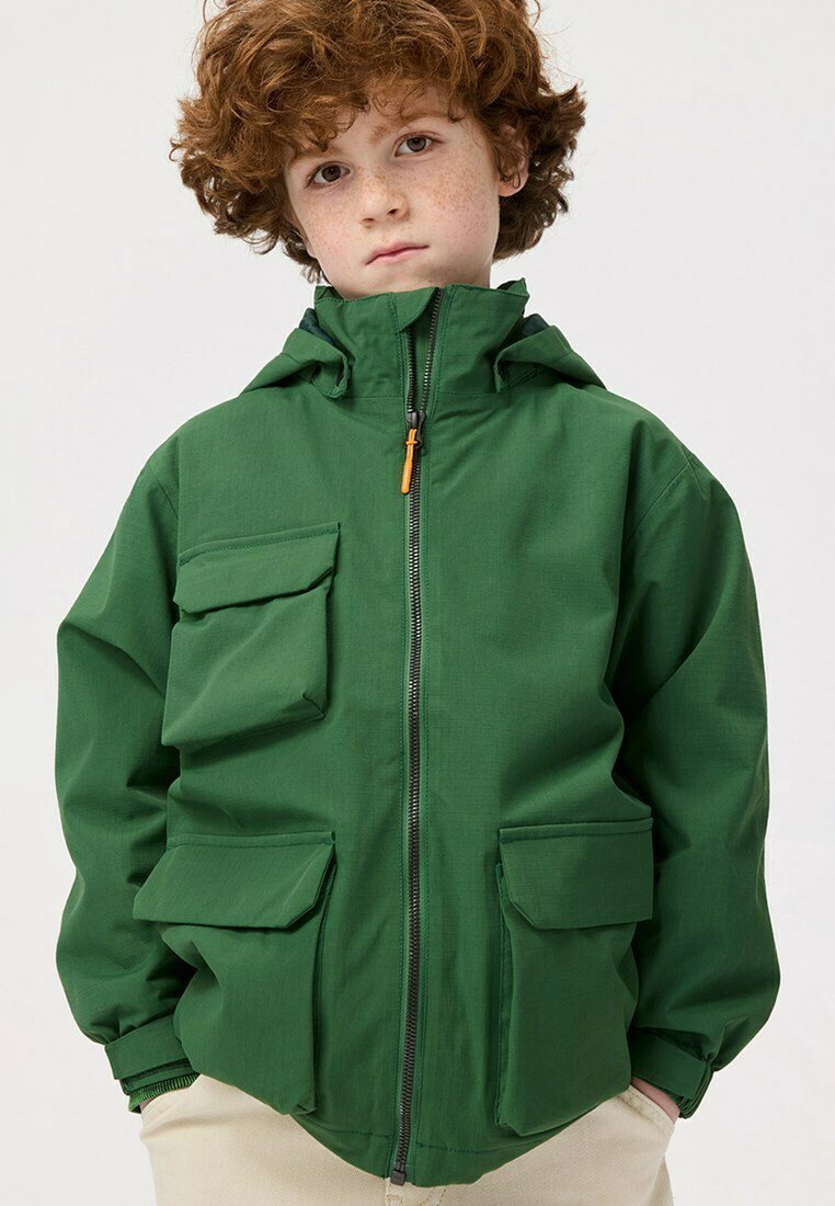 Groene jas met een capuchon, voorzien van een volledige ritssluiting, vier zakken en een soepele textuur. Ontworpen in een praktische, oversized vorm.