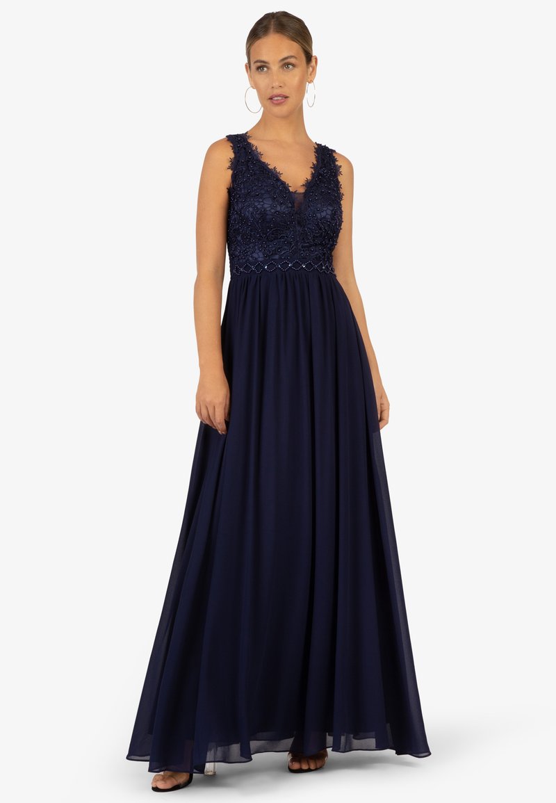 Abito lungo blu navy con corpetto in pizzo floreale, scollatura a V e gonna fluida. Presenta perline delicate e vita aderente.