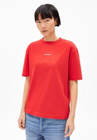 Rotes Baumwoll-T-Shirt mit kurzen Ärmeln und Rundhalsausschnitt. Mit einem kleinen weißen Logo, das in der Mitte der Brust platziert ist. Lockere Passform und glatte Textur.